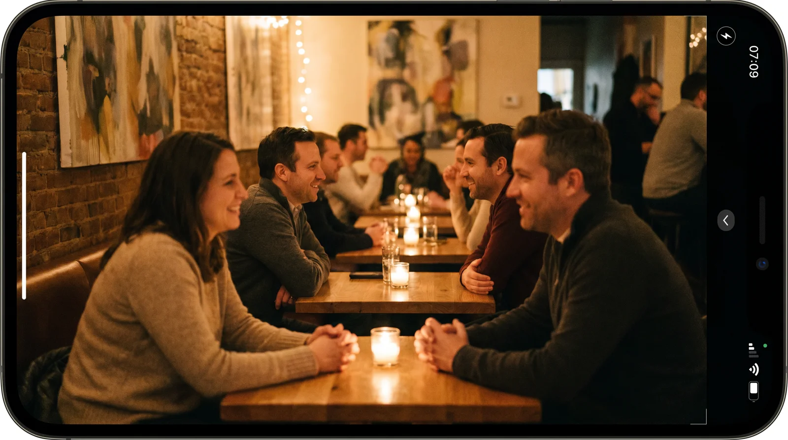 Pairs of people in conversation at small candlelit tables during a speed dating event