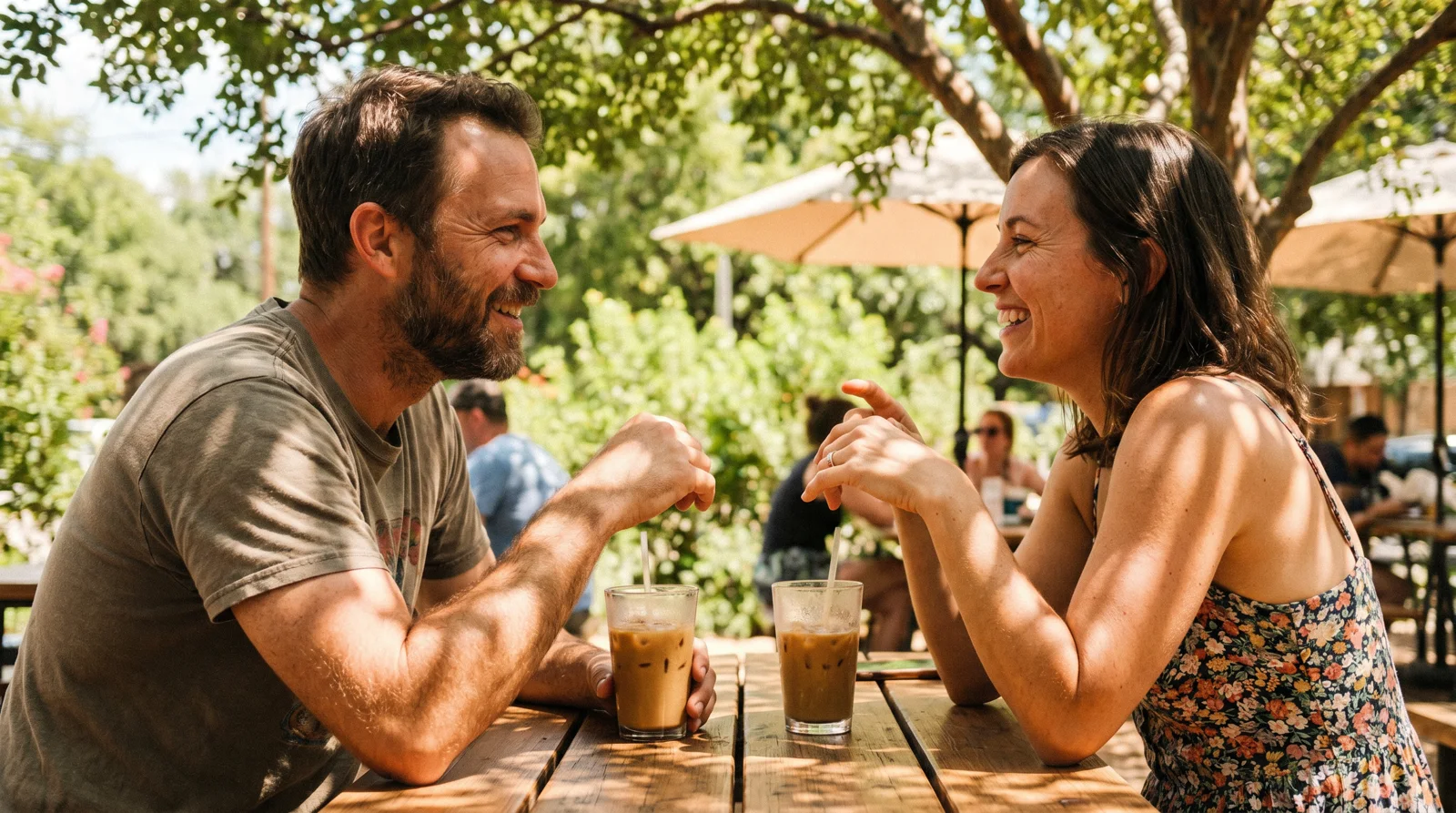 Man and woman on a relaxed daytime coffee date at a bright Dallas cafe patio